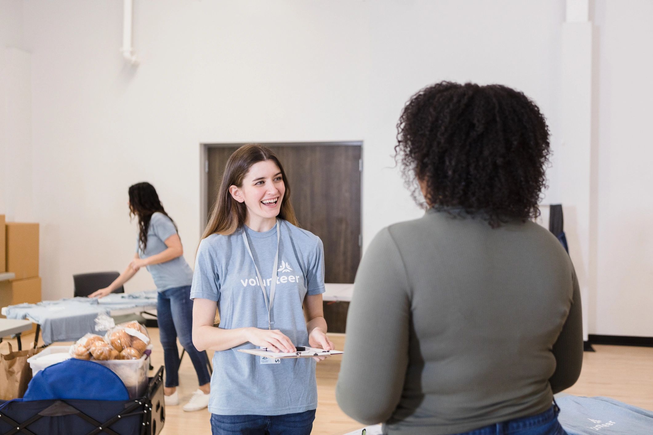 Volunteer welcoming someone at a community table